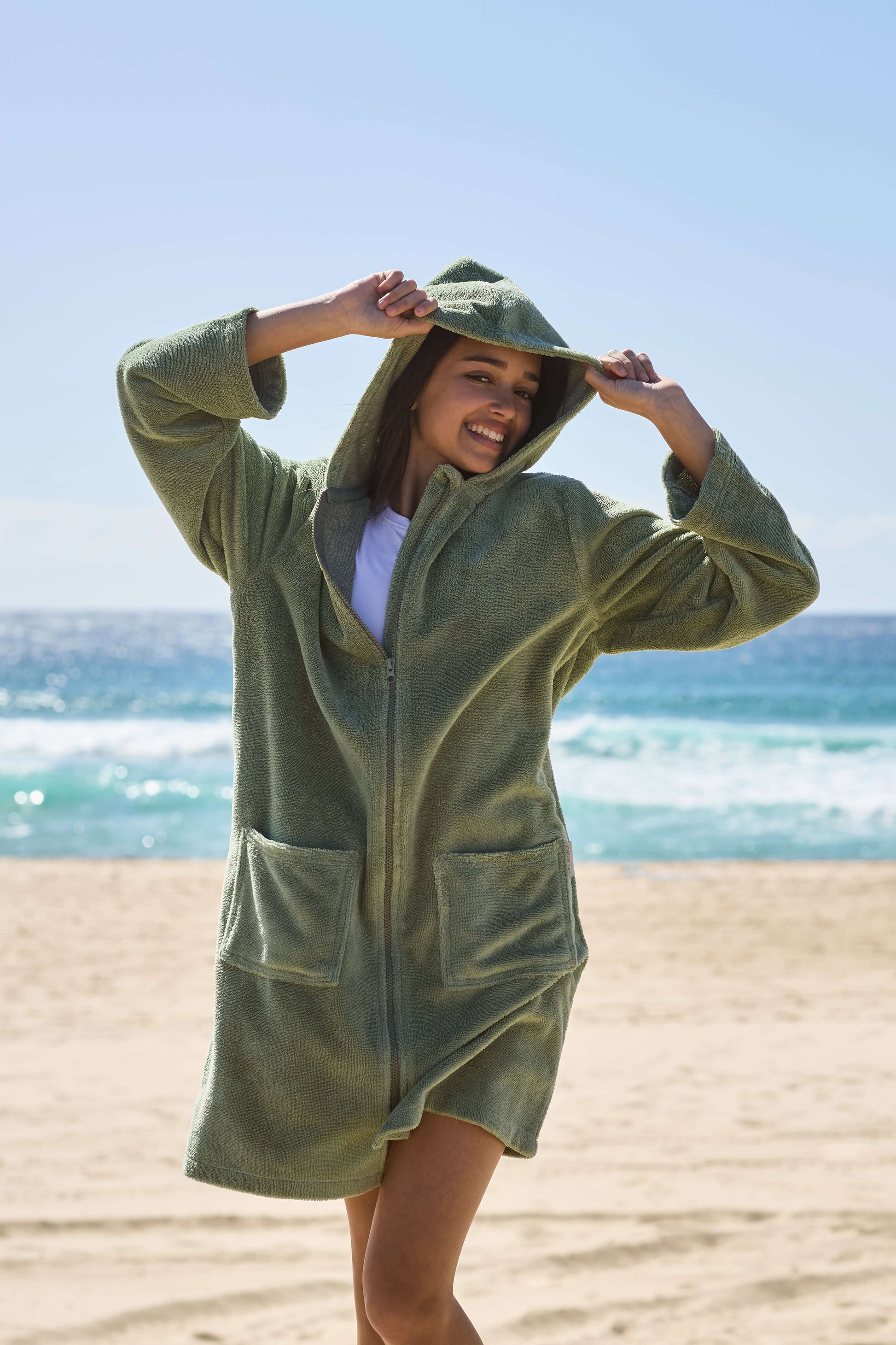 Young lady smiling at life with her green hooded towel on. Cactus Pre Teens & Teens