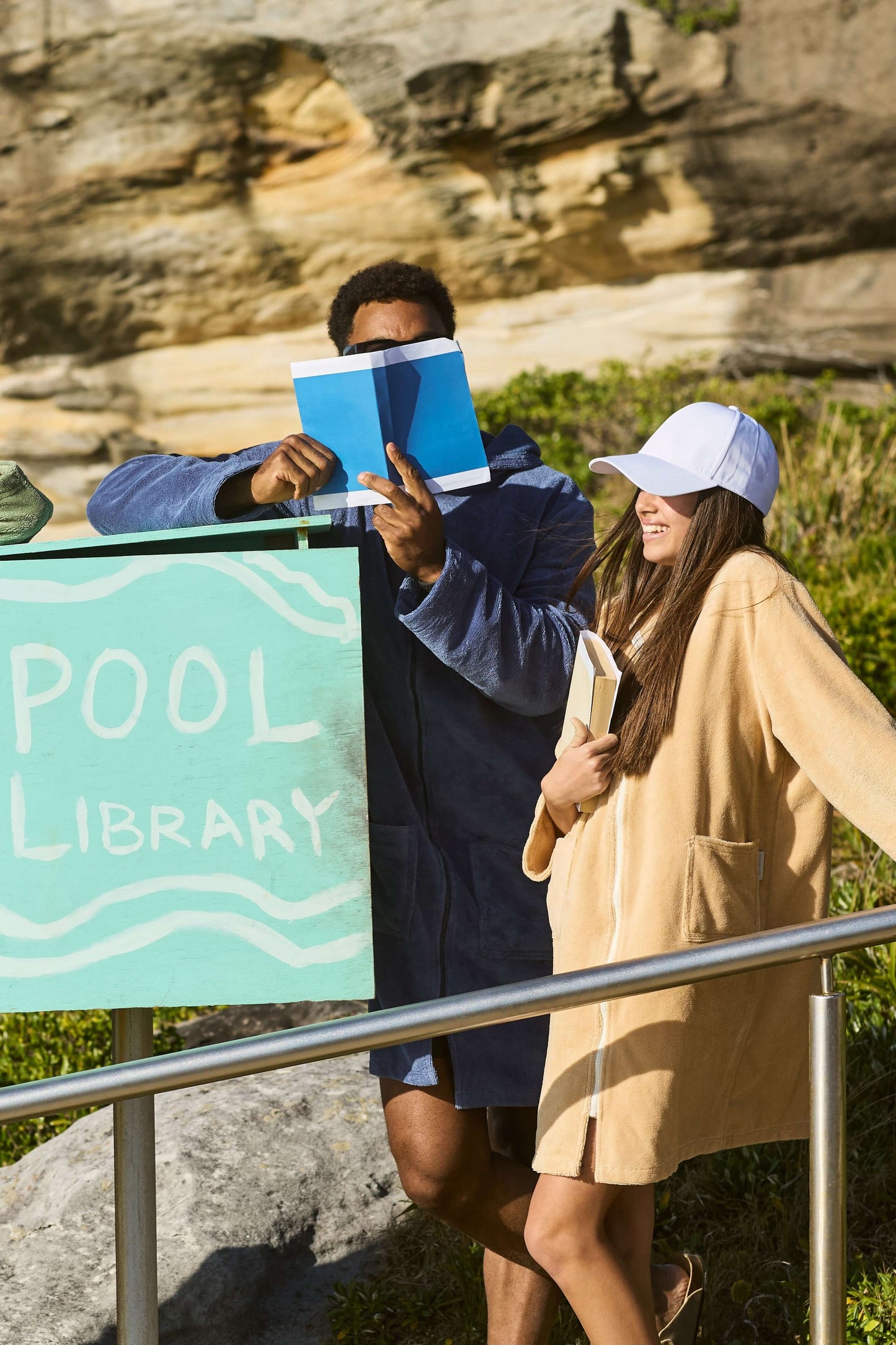 Dad and daughter reading books with their hooded towels on, during the weekend. Sandcastle Pre Teens & Teens